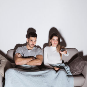 a couple sitting together and watching tv